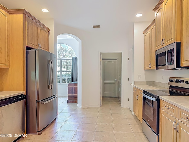 12 Kathleen Trl, Palm Coast, FL 32164 - kitchen with stainless steel appliances, light tile patterned floors, arched walkways, light countertops, and recessed lighting