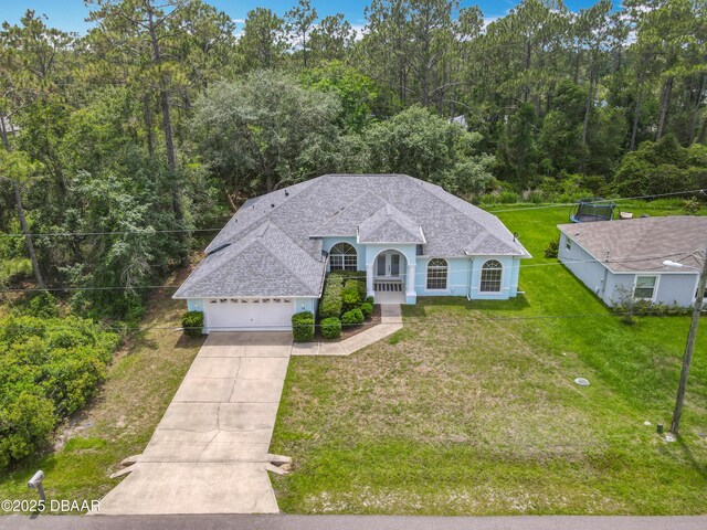 12 Kathleen Trl, Palm Coast, FL 32164 - ranch-style home featuring concrete driveway, roof with shingles, a front lawn, and an attached garage