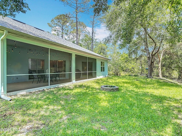 12 Kathleen Trl, Palm Coast, FL 32164 - view of grassy yard featuring an outdoor fire pit and a sunroom