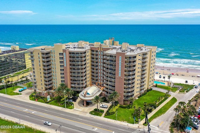 birds eye view of property with a water view and a beach view