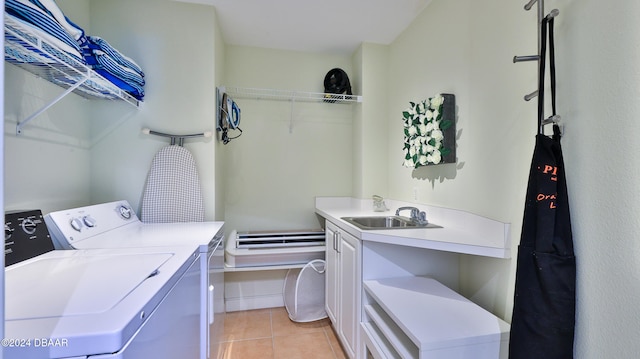 washroom with light tile patterned floors, cabinets, sink, a baseboard heating unit, and washing machine and dryer