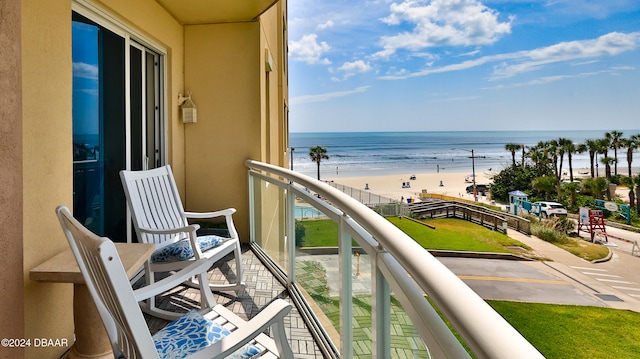 balcony featuring a beach view and a water view