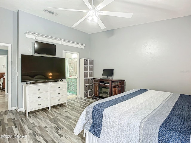 bedroom featuring ensuite bathroom, wood finished floors, visible vents, and a ceiling fan