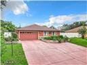 ranch-style house with a front lawn, driveway, and an attached garage