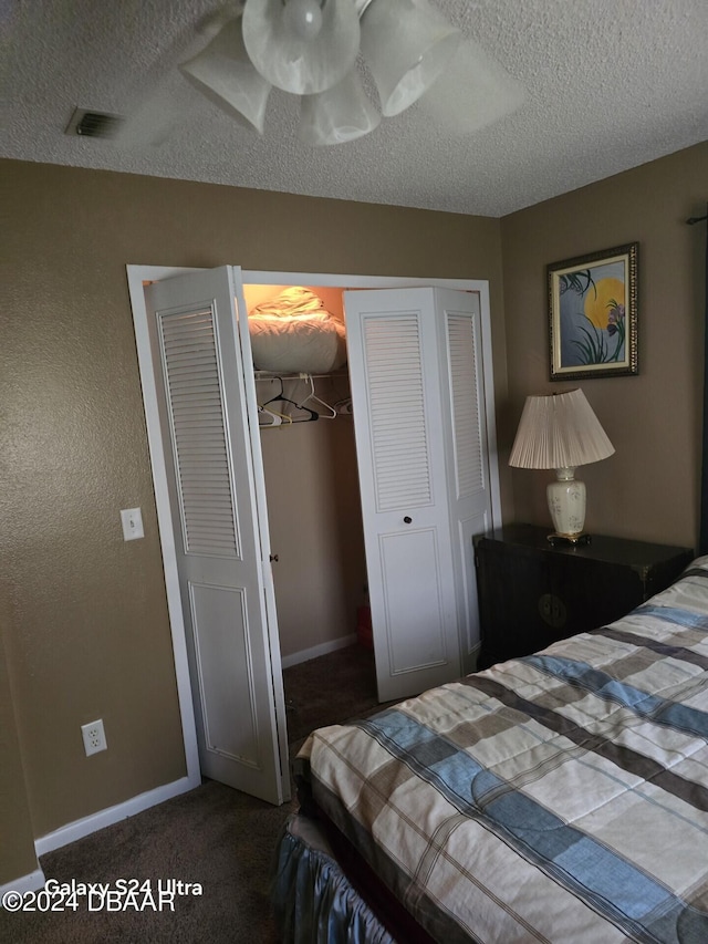 carpeted bedroom featuring a textured ceiling and a closet