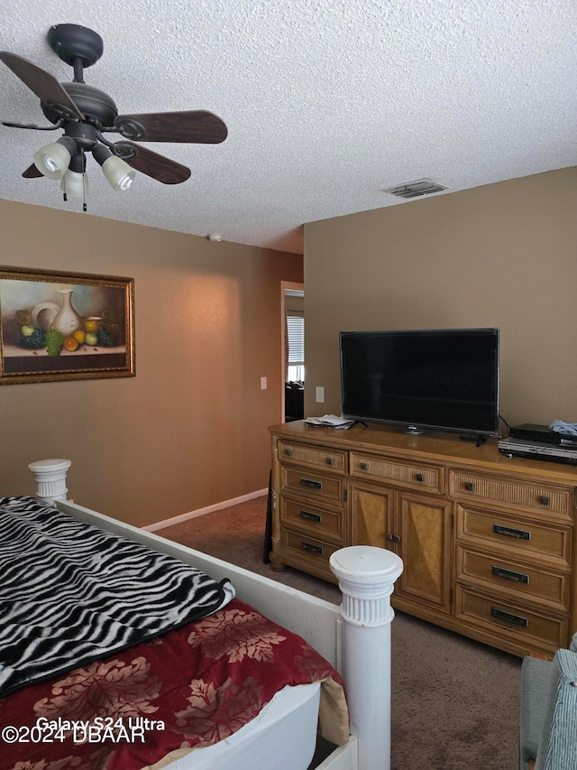 bedroom featuring ceiling fan, a textured ceiling, and dark carpet