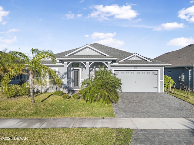 view of front of property with stucco siding, a front lawn, decorative driveway, and a garage