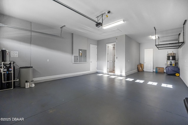 garage featuring electric panel, a garage door opener, and baseboards