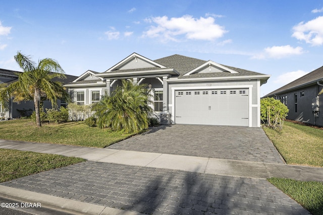 view of front facade featuring a garage, stucco siding, decorative driveway, and a front yard