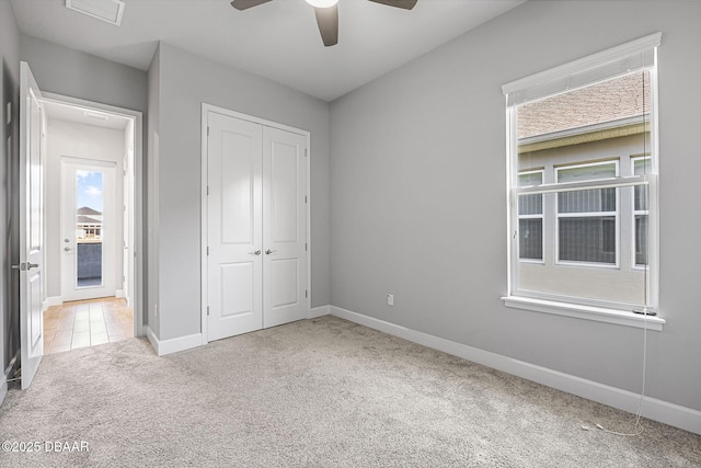 unfurnished bedroom featuring visible vents, a ceiling fan, a closet, carpet, and baseboards