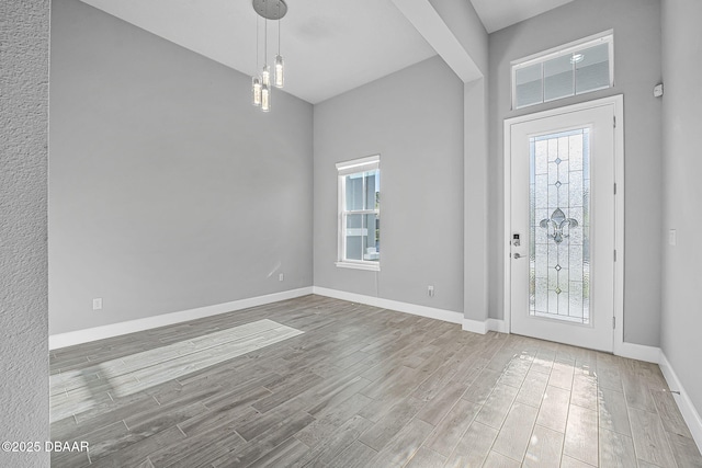 entrance foyer with plenty of natural light, baseboards, and wood tiled floor