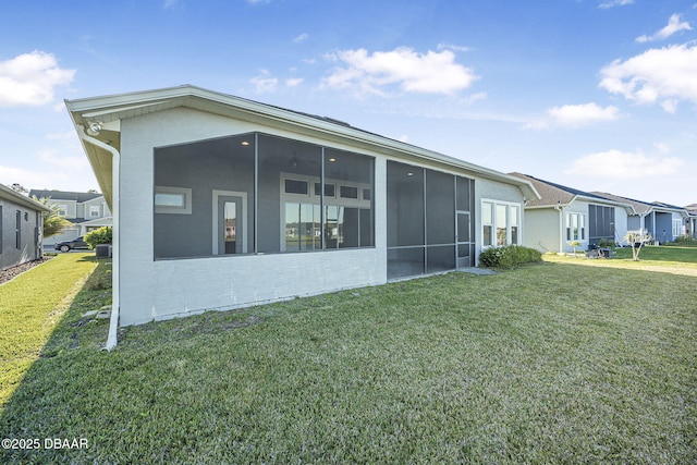 rear view of house with a lawn, a residential view, and a sunroom