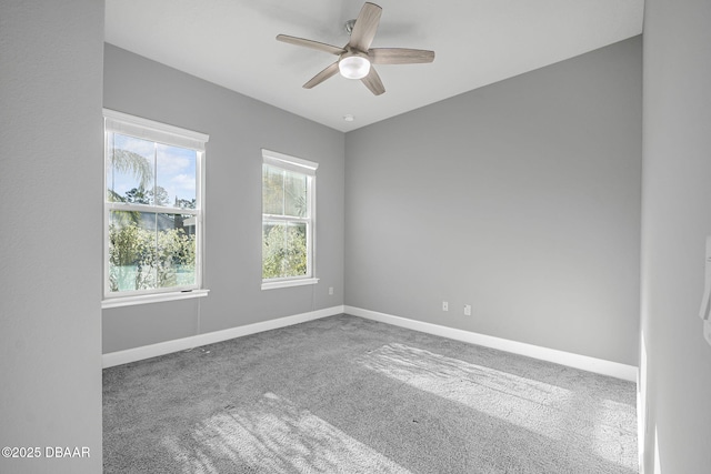 carpeted empty room with baseboards and a ceiling fan