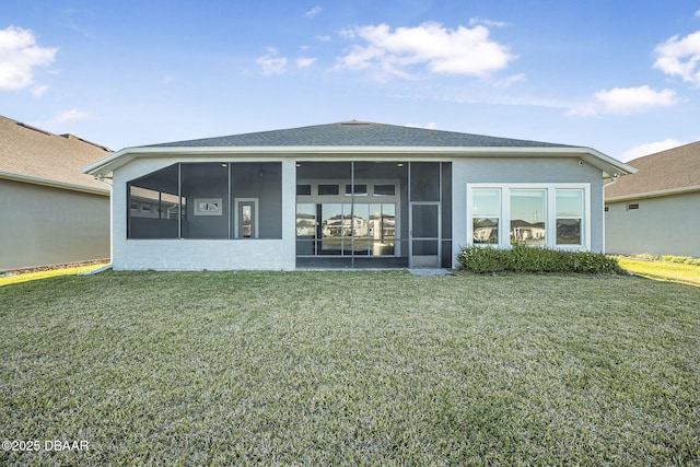 rear view of property featuring stucco siding, a lawn, and a sunroom