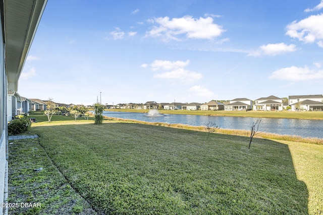 view of yard featuring a residential view and a water view