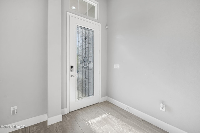 foyer with baseboards and wood finished floors