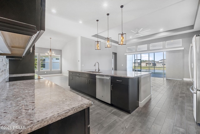 kitchen featuring a kitchen island with sink, dark cabinetry, open floor plan, and appliances with stainless steel finishes