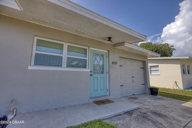 doorway to property with a garage