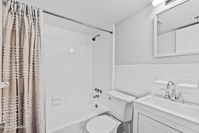 full bathroom with tile walls, vanity, shower / bath combination with curtain, and toilet