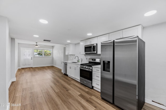 kitchen with light hardwood / wood-style floors, white cabinets, sink, ceiling fan, and appliances with stainless steel finishes