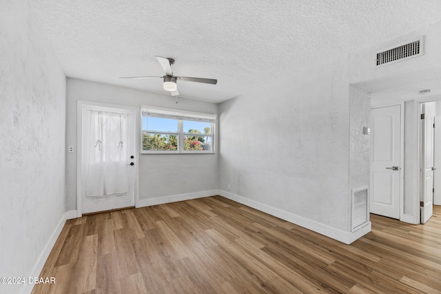 empty room with light wood-type flooring, a textured ceiling, and ceiling fan