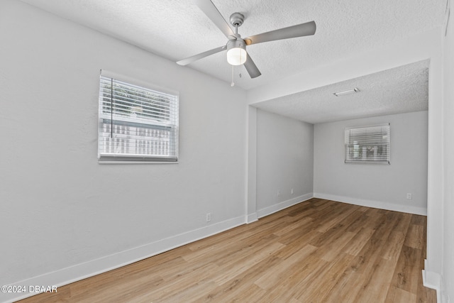 unfurnished room featuring light hardwood / wood-style flooring, a textured ceiling, and ceiling fan