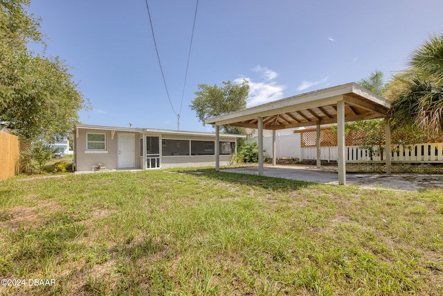 view of yard with a sunroom and a carport