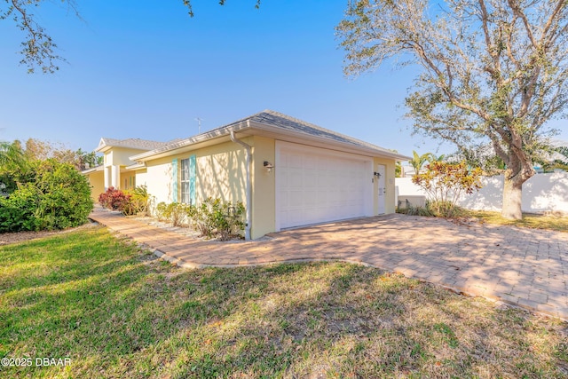 view of side of property featuring a garage and a lawn