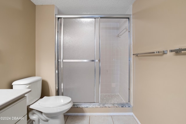 bathroom featuring a textured ceiling, vanity, tile patterned floors, and walk in shower