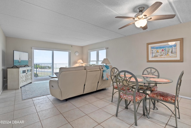 tiled dining space with ceiling fan and a textured ceiling