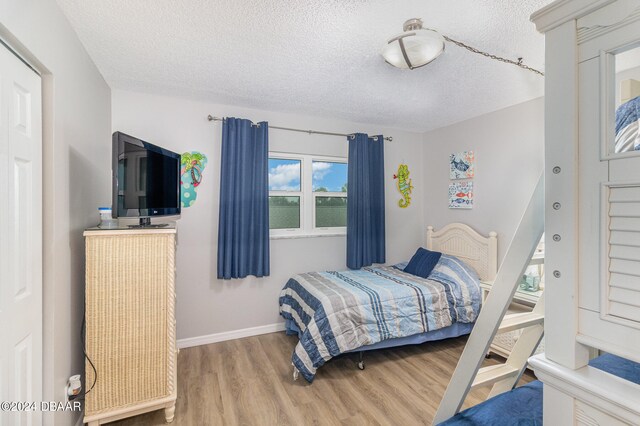 bedroom with wood-type flooring and a textured ceiling