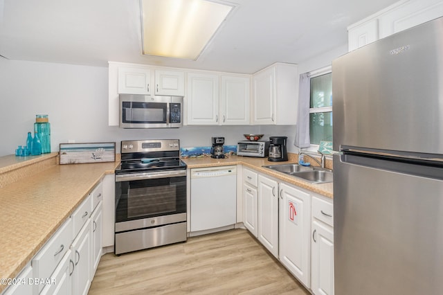 kitchen featuring appliances with stainless steel finishes, sink, and white cabinets