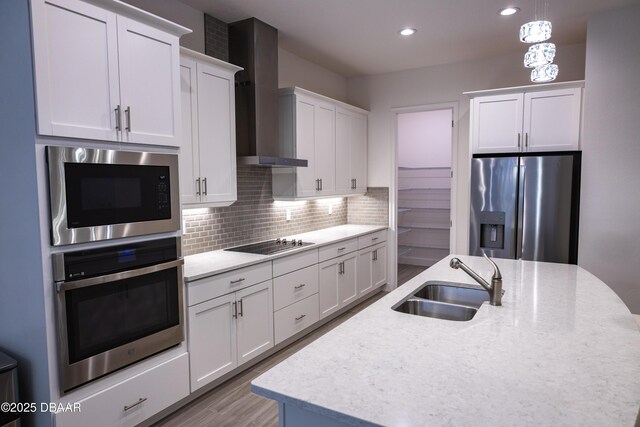 437 Aquamarine Way, Daytona Beach, FL 32124 - kitchen featuring appliances with stainless steel finishes, wall chimney range hood, a center island with sink, white cabinets, and backsplash