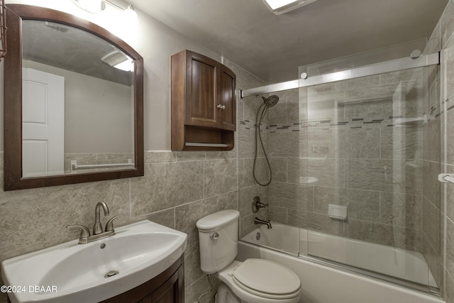 full bathroom with combined bath / shower with glass door, decorative backsplash, vanity, tile walls, and toilet