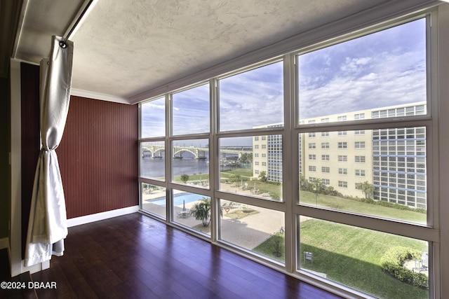 unfurnished sunroom featuring a water view