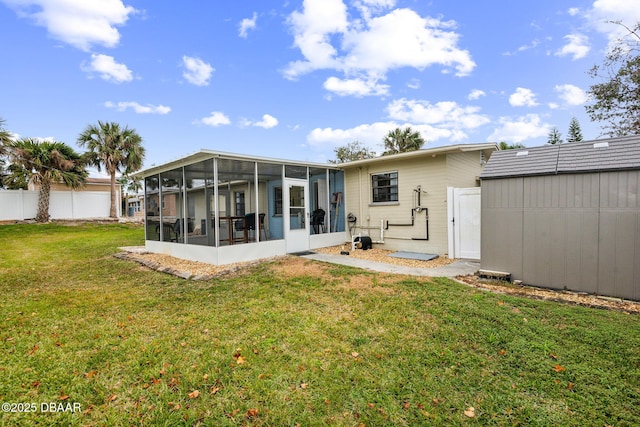 back of property with a yard and a sunroom