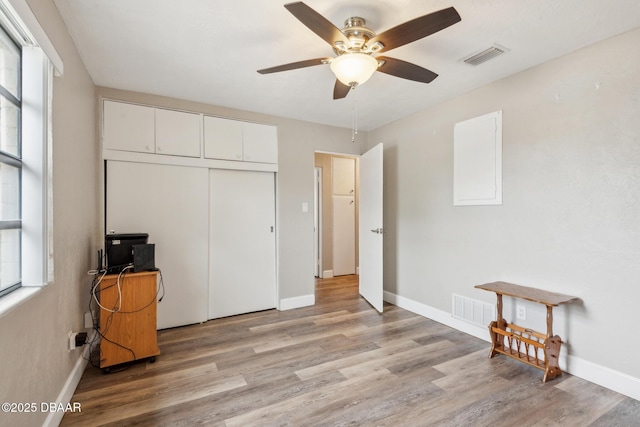 bedroom with ceiling fan, light hardwood / wood-style floors, and a closet