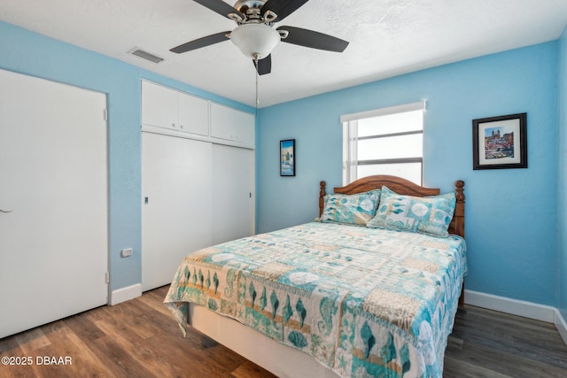 bedroom featuring dark hardwood / wood-style floors, ceiling fan, and a closet