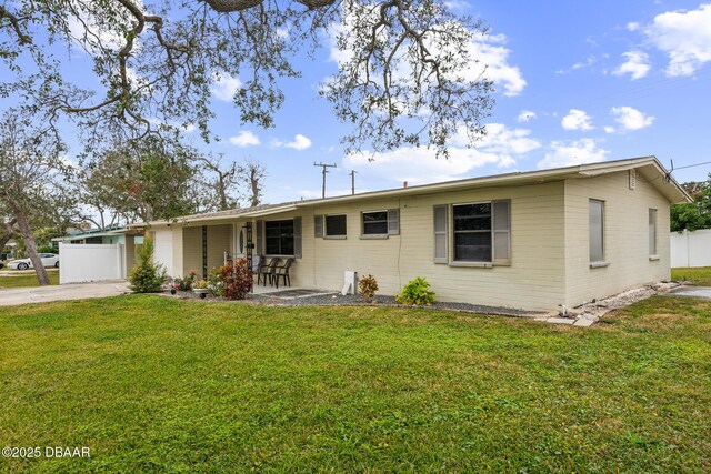 rear view of property with central AC, a yard, and a sunroom