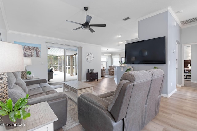 living room with crown molding, a wealth of natural light, and light hardwood / wood-style flooring