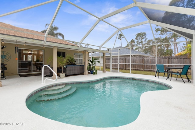 view of pool featuring glass enclosure and a patio area