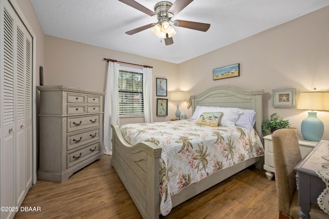 bedroom featuring hardwood / wood-style floors, ceiling fan, a textured ceiling, and a closet