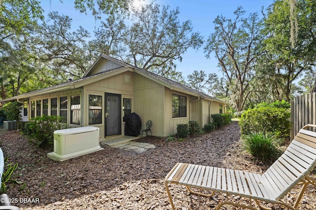 view of property exterior with a sunroom and central air condition unit