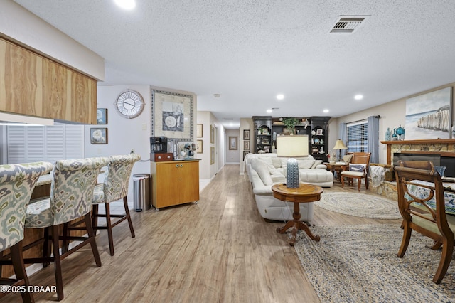 living room featuring light wood-type flooring and a textured ceiling