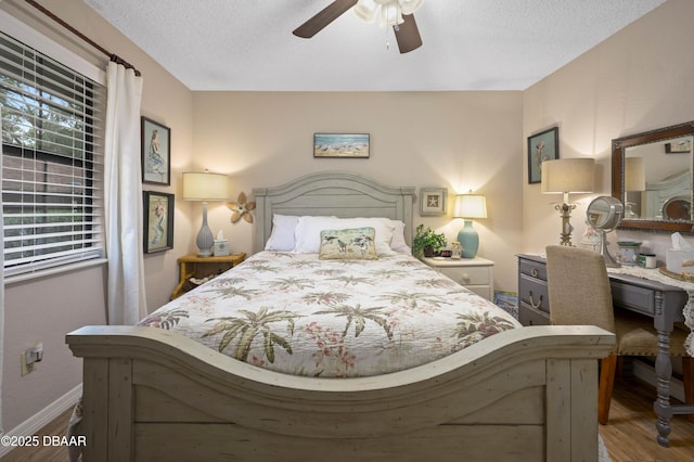 bedroom with ceiling fan, hardwood / wood-style floors, and a textured ceiling