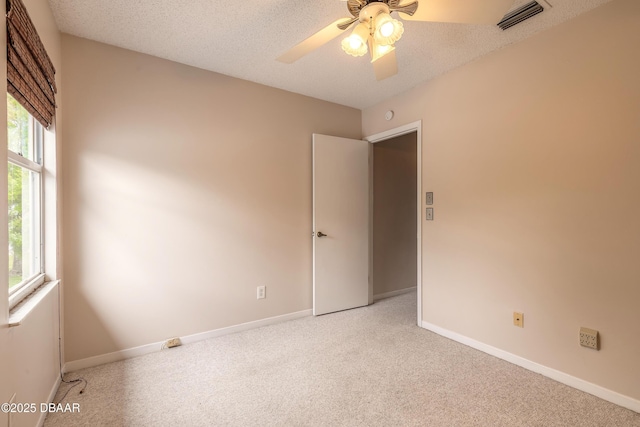 936 Meadow View Dr Unit A, Port Orange, FL 32127 - empty room with light carpet, a ceiling fan, baseboards, and a textured ceiling