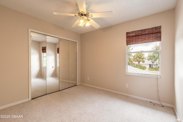 936 Meadow View Dr Unit A, Port Orange, FL 32127 - unfurnished bedroom with carpet flooring, a closet, a ceiling fan, baseboards, and a textured ceiling