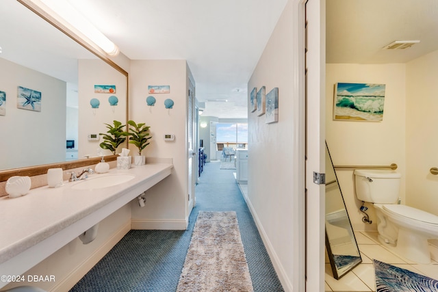 bathroom featuring toilet, tile patterned floors, and sink