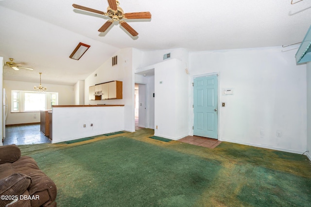 355 Palm Cir, Flagler Beach, FL 32136 - unfurnished living room with lofted ceiling, a ceiling fan, baseboards, carpet floors, and a chandelier