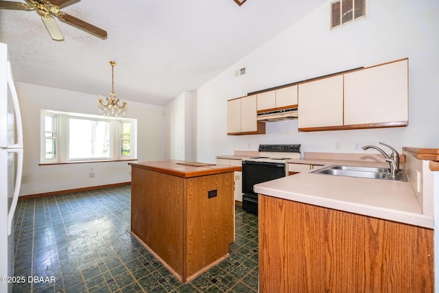 355 Palm Cir, Flagler Beach, FL 32136 - kitchen with range with electric stovetop, a sink, vaulted ceiling, a center island, and light countertops